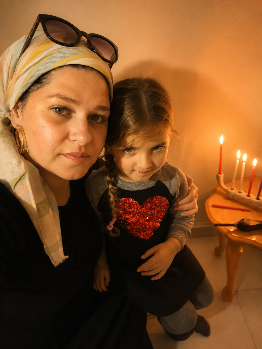 הילה אזרד ובתה ליד נרות דולקים