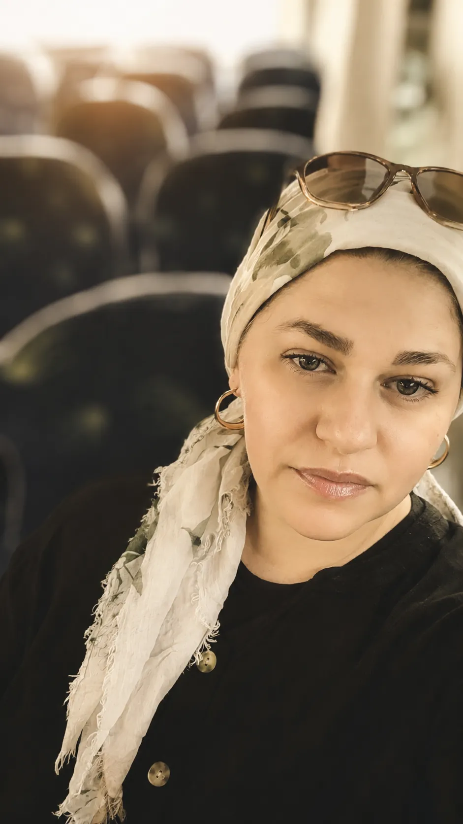 הילה אזרד יושבת בין שורות כיסאות ריקות